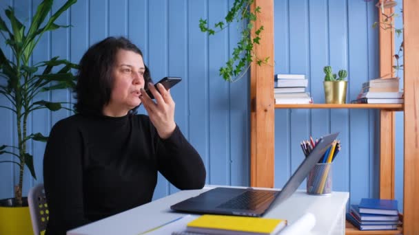 Middelbare vrouw hold telefoon spreken activeren virtuele digitale spraakherkenning assistent thuis. Mobiele ai technologie concept — Stockvideo