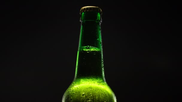 Garrafa de cerveja girando contra fundo escuro. — Vídeo de Stock