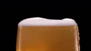 Hafif bira bardağa dökülüyor. Köpüklü ve köpüklü. Soğuk ve ferahlatıcı bira..