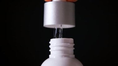 Bir adamın eli serumla bir damlatıcıyı alır ve kaldırır. yakın plan