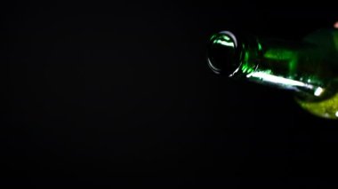 Yavaş çekimde açık yeşil cam şişeden bira akışı akıyor, soğuk bira dökülüyor, sıvı akışı, içecek masası, alkol içeceği.