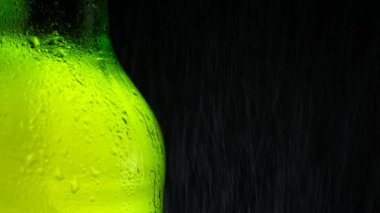 Soğuk yeşil bir şişe taze ve ferahlatıcı biraya su püskürtülür..
