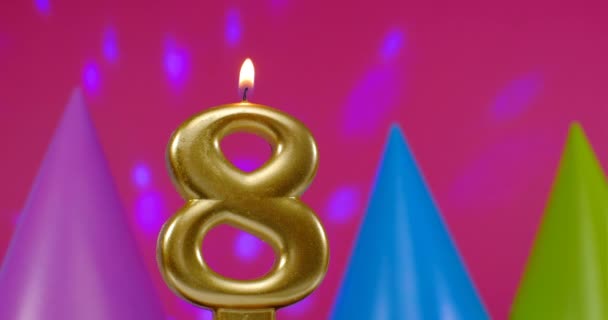 Зажигаю свечу для торта номер 8. Концепция празднования Дня Рождения. День рождения шляпа на заднем плане — стоковое видео