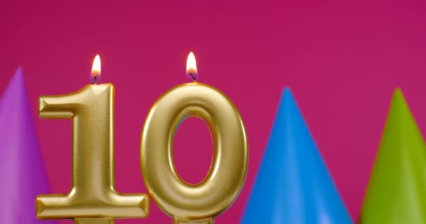 Burning birthday cake candle number 10. Happy Birthday background anniversary celebration concept. Birthday hat in the background — Stock Video