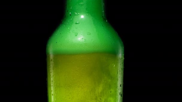 Ergue-se bolhas e espuma dentro da garrafa de cerveja verde. — Vídeo de Stock