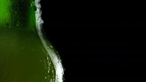 Water drops falling down on the glass of beer. Water drops on green glass close up view. Rain drops on bottle. Water droplets falling on glass surface. Water drops falling vertical. Drop. — Stock Video