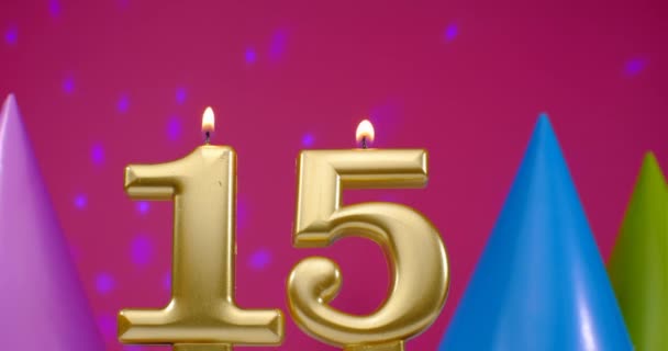 Burning birthday cake candle number 15. Happy Birthday background anniversary celebration concept. Birthday hat in the background — Stock Video