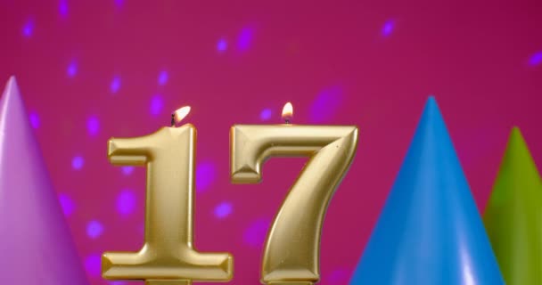 Burning birthday cake candle number 17. Happy Birthday background anniversary celebration concept. Birthday hat in the background — Stock Video