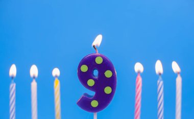 9 numaralı doğum günü pastası mumu yanıyor. Mutlu yıllar yıldönümü kutlaması konsepti