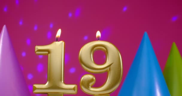 Vela de pastel de cumpleaños ardiente número 19. Feliz cumpleaños aniversario de fondo concepto de celebración. Sombrero de cumpleaños en el fondo — Vídeo de stock