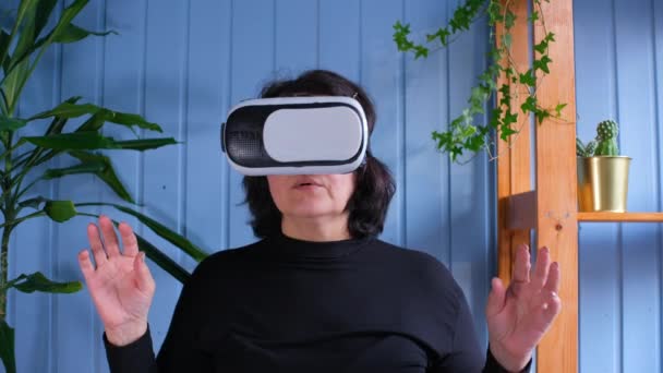 Yaşlı kadın sanal gerçeklik gözlüğü kullanıyor. Yaşlılar ve modern teknoloji kavramı — Stok video