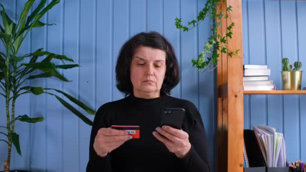 Yetişkin bir kadın online alışveriş için kredi kartı kullanıyor. Yaşlılar ve modern teknoloji kavramı — Stok video