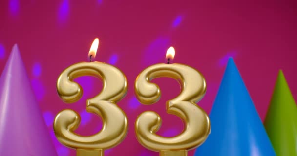 Vela de bolo de aniversário em chamas número 33. Feliz aniversário aniversário conceito celebração aniversário. Chapéu de aniversário no fundo — Vídeo de Stock