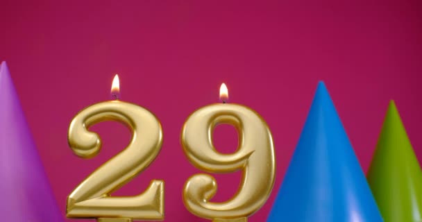 Зажигаю свечу для торта номер 29. Концепция празднования Дня Рождения. День рождения шляпа на заднем плане — стоковое видео
