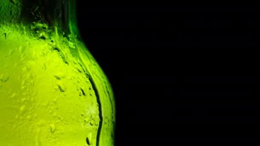Bira şişesi camına damlayan yoğunlaştırılmış damlalar 4K yakın çekim yavaş çekim videosu. Siyah zemine düşen su damlaları