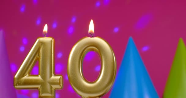 Burning birthday cake candle number 40. Happy Birthday background anniversary celebration concept. Birthday hat in the background — Stock Video