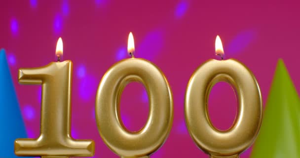 Brennende Geburtstagskuchenkerze Nummer 100. Happy Birthday Hintergrund Jubiläumsfeier Konzept. Geburtstagshut im Hintergrund — Stockvideo