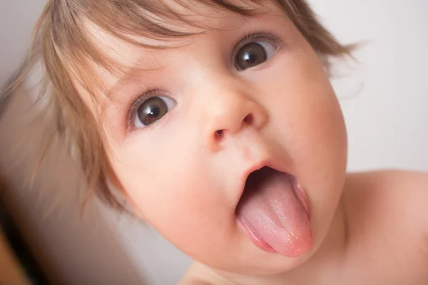 Söt baby visar tungan Royaltyfria Stockfoton