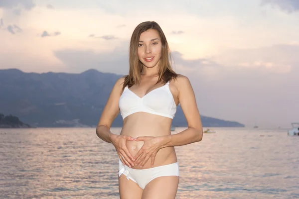 Красивая беременная женщина на пляже — стоковое фото