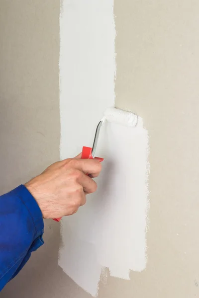 Hombre usando rodillo de pintura en la pared — Foto de Stock