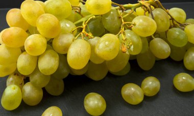 Siyah bir masada büyük bir demet üzüm.