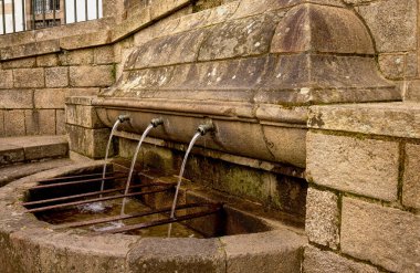 Üç su kaynağı olan eski taş çeşme.