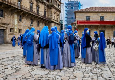 Şehir meydanında mavi ve gri giysili birkaç rahibe.