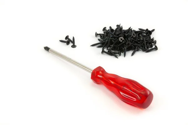 Red screw driver and black screw — Stock Photo, Image