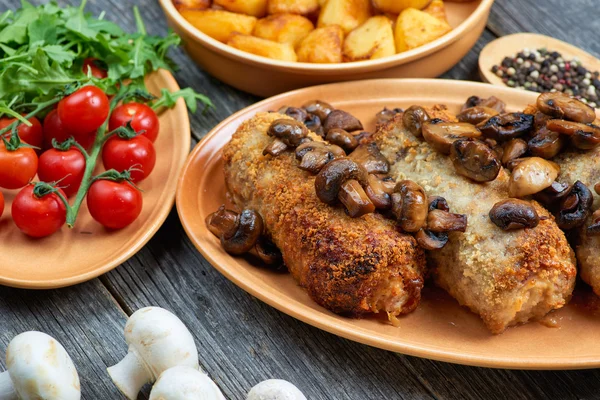 Roulade van varkensvlees met geroosterde paddenstoelen en aardappelen — Stockfoto