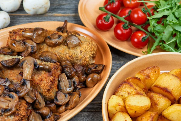 Roulade van varkensvlees met geroosterde paddenstoelen en aardappelen — Stockfoto