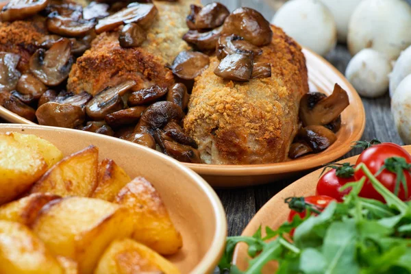 Roulade van varkensvlees met geroosterde paddenstoelen en aardappelen — Stockfoto