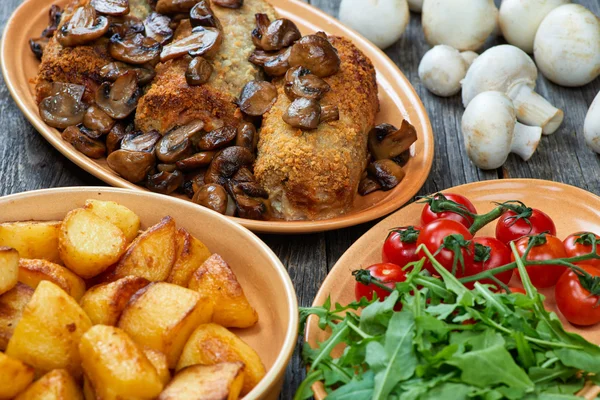 Roulade van varkensvlees met geroosterde paddenstoelen en aardappelen — Stockfoto