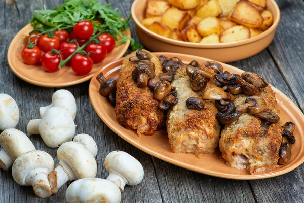 Roulade van varkensvlees met geroosterde paddenstoelen en aardappelen — Stockfoto