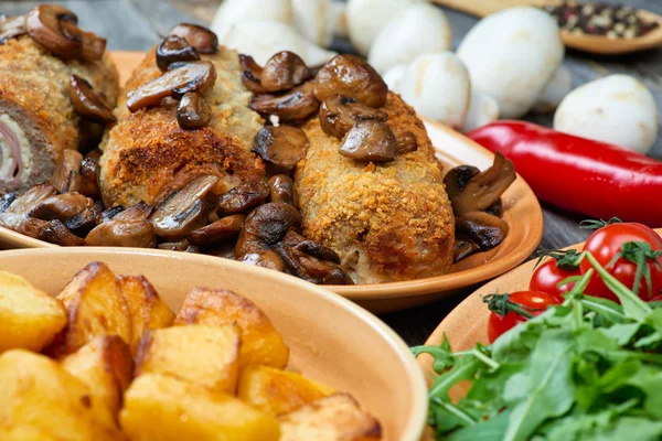 Roulade van varkensvlees met geroosterde paddenstoelen en aardappelen — Stockfoto