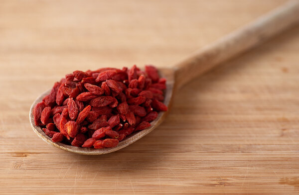 dried goji berries on the wooden spoon
