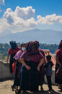 Maya kadınları arka planda dağla mutlu bir şekilde sohbet ediyorlar.