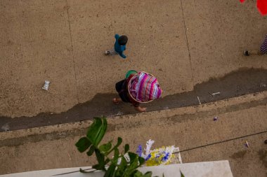 Sokakta yürüyen kadın kafasında sepetle dolaşıyor.