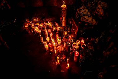 Yerde koyu arkaplanı yanan renkli mumlar.