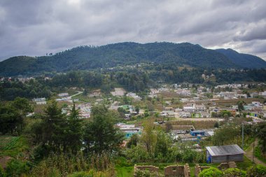 Vadi manzaralı evler ve bulutlu hava ile orman dağları