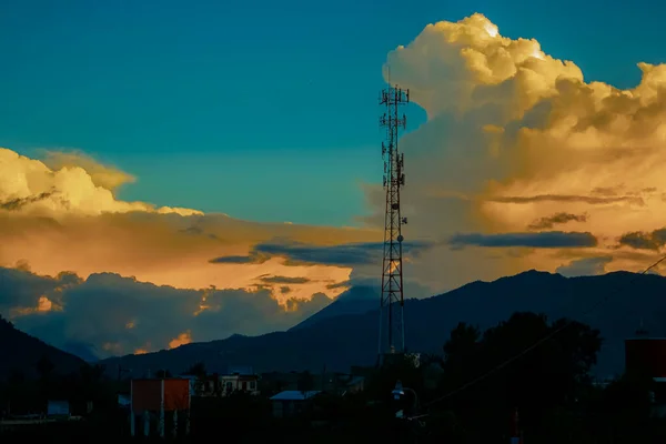 Günbatımı Manzarası Ile Siyah Dağlar Sarı Bulutlar Mezarlıkta Anten Kulesi — Stok fotoğraf