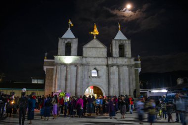 church with people in front of night with moon