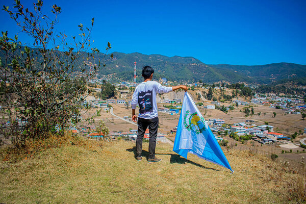 молодой человек с гватемальским флагом на скале