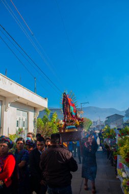 Güzel çiçekler Guadalupe 'nin bakiresini taşıyan insanlarla süslüyor.