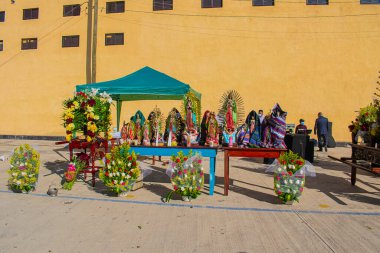 Güzel çiçekler ve sarı arka planlı Guadalupe bakiresinin resimleri.