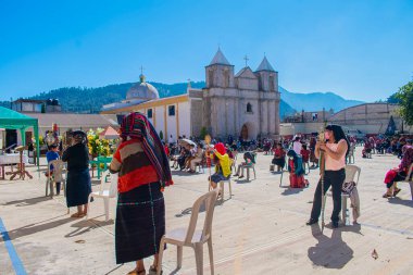 Kutsal kitle, kilisenin önünde oturan yerli halkla birlikte covid 19 salgınının ortasında.