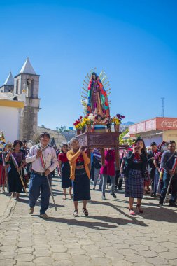 Sokaklarda yürüyen yerli halk Gudalupe 'nin bakiresi imajıyla