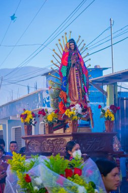 Kutsal Guadalupe bakiresi tahtanın üzerinde çiçeklerle
