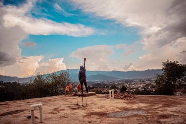 Köpeği ve güzel manzaralı genç bir adam.