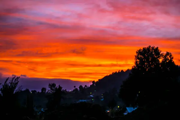 Gün Batımında Kırmızı Gökyüzü Dağlı Ağaçların Siluetiyle — Stok fotoğraf