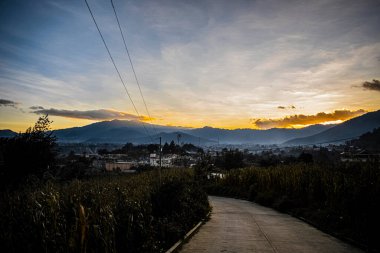 Güzel bir yol, kırmızı bulutlu gün batımı, gökyüzü ve vadi ve dağlar.